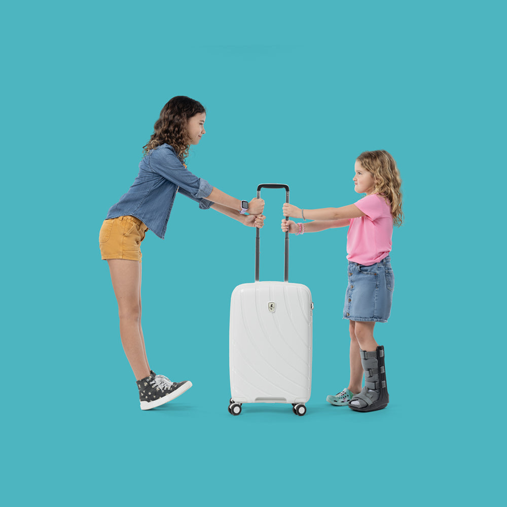 two girls holding extended handle of shell white carry on